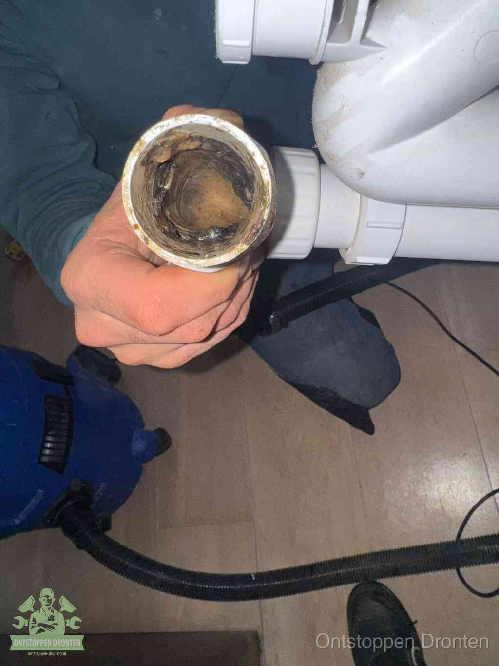 Een losgekoppeld afvoerbuisstuk dat van binnen volledig is dichtgeslibd, het gevolg van een verstopping te lang laten zitten in Dronten