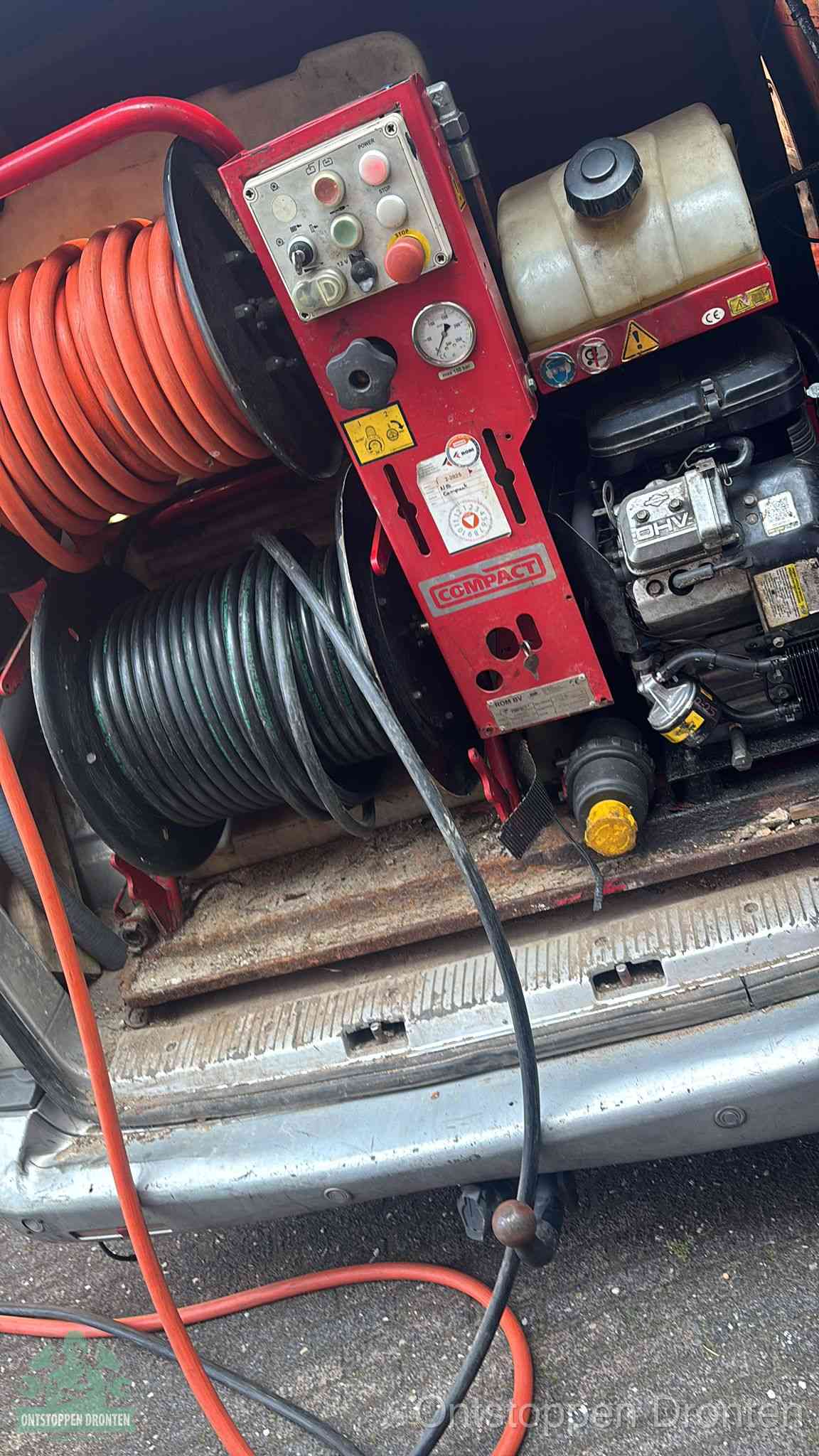 Een rood hogedruk-rioolreinigingstoestel in de laadbak van de bedrijfsbus, apparatuur voor een hardnekkige afvoerverstopping in Dronten