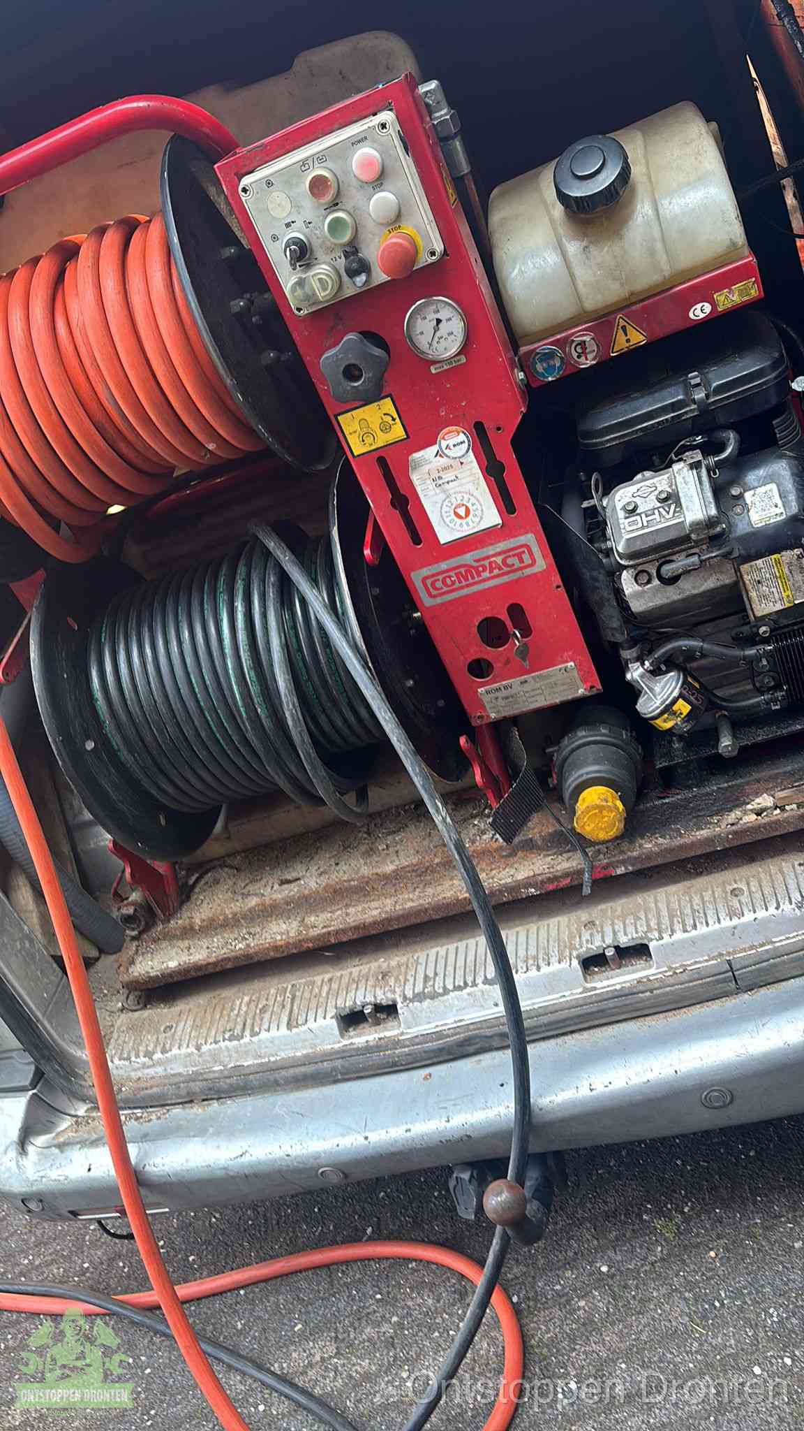Een rood hogedruk-rioolreinigingstoestel met slangen in de laadbak van de bedrijfsbus, apparatuur voor een hardnekkige wc-verstopping in Dronten