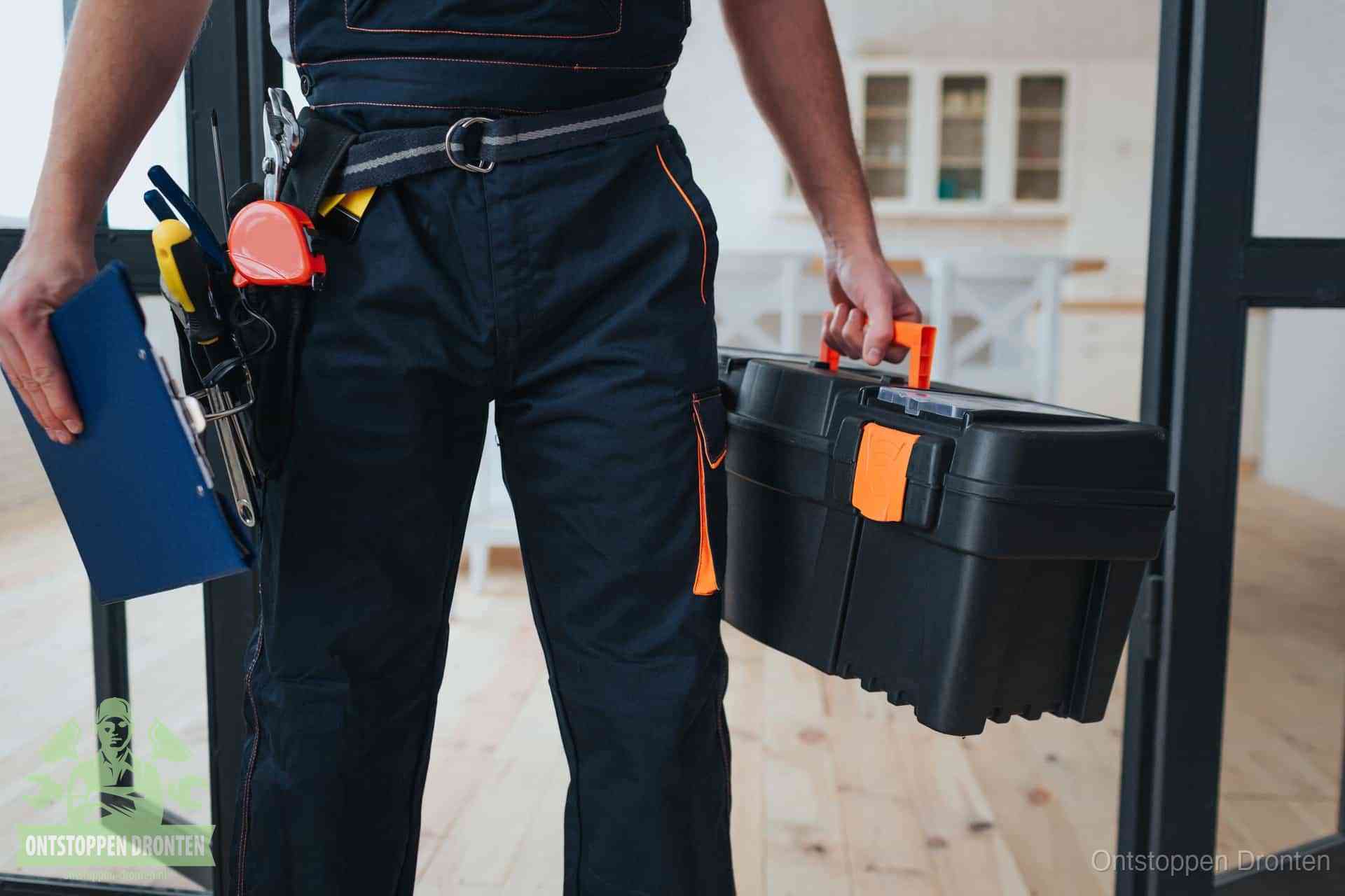 Een monteur met gereedschapsriem en klembord, klaar om een transparante prijs voor het wc ontstoppen in Dronten te geven