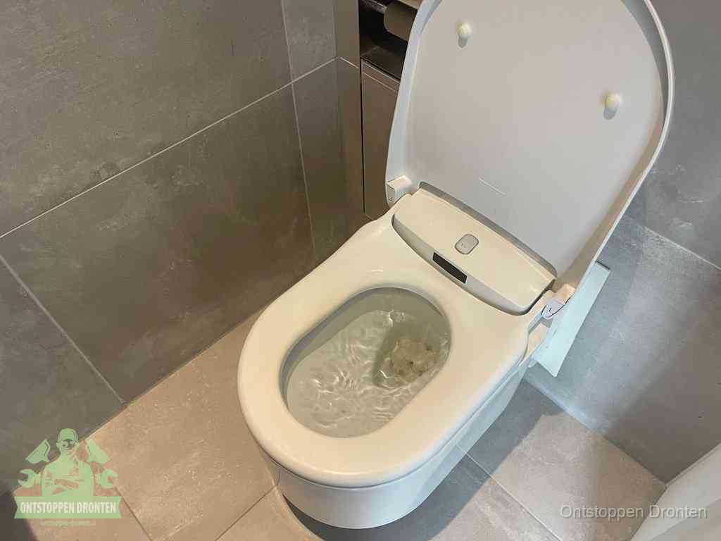 Een toiletpot vol troebel water met drijvend papier en restanten, de meest voorkomende oorzaak van een verstopte wc in Dronten