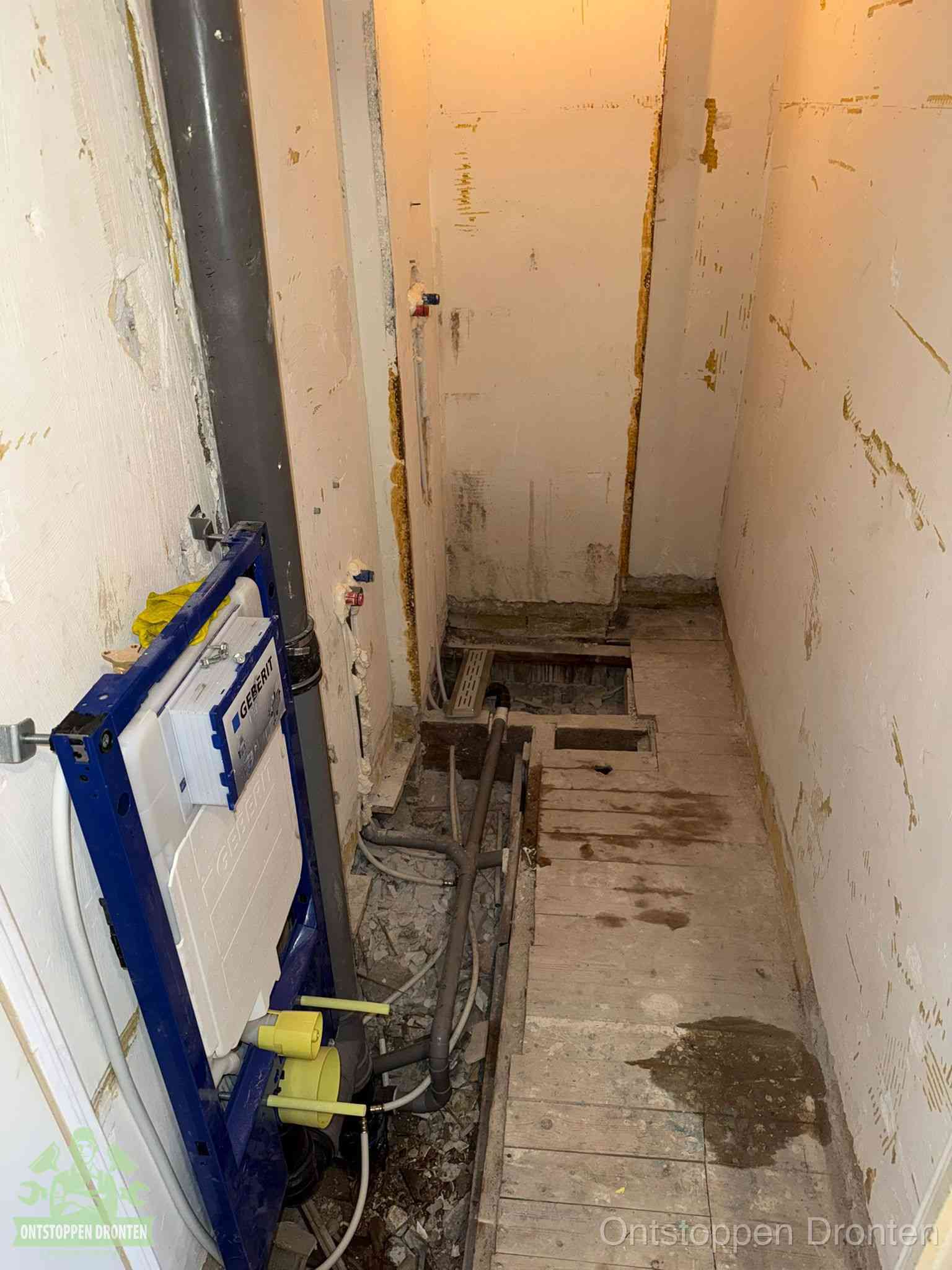 Een opgebroken toiletruimte tijdens renovatie met een Geberit inbouwreservoir en blootliggende oude afvoerleidingen, typisch voor oudere woningen in Dronten